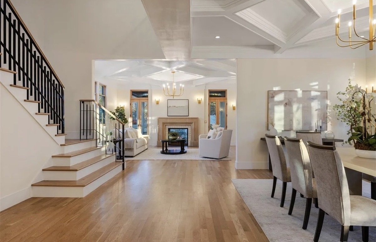 Grand foyer with a black iron staircase and views into the formal living and dining rooms